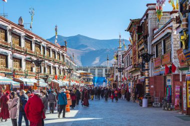 Lhasa, Tibet, Çin - 15 Kasım 2019 Jokhang Tapınağı 'nın etrafındaki bakuo yolu. Dua etmek için insanlar tapınağın etrafında saat yönünde yürüyorlar. Arka planda Himalaya 'nın