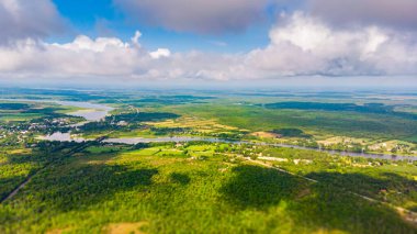 Kanada Manzarası üzerinde, Merrickville, Ontario 'da, Ottawa şehrinin yakınında. Mavi gökyüzünün altındaki yeşil arazide bir nehir kıvrılır. İHA görüntüsü, bulutların üstünde 