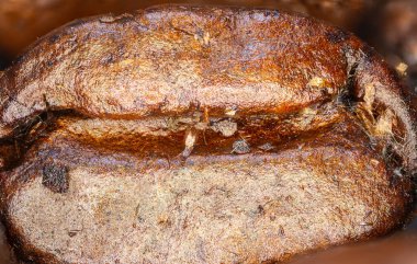 Fasulyeli kahve. Makro panorama kahve çekirdeklerinin yüksek çözünürlüklü fotoğrafları. Kavrulmuş kahve çekirdeğinin üzerinde ultra makro detaylar. Mikroskobik fotoğrafçılık. Kahve dükkanında afiş olarak kullanışlı.