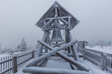 Doğu Alman dağı Erzgebirge 'in karlı kış manzarası. Kışın Fichtelberg 'in zirvesinde. Dallarında çok kar taşıyan ağaçlar. Kar yağdıktan sonra bulutlu bir gökyüzü. en yüksek dağ