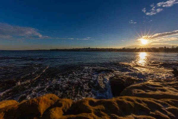 オーストラリア シドニーのボンディビーチ周辺の岩だらけの海岸線 有名なサーファーのビーチの近くの夕日 太平洋上の日没 太陽が滑らかな水の中に反映 カラフルな海側の夕日を息をのむ — ストック写真