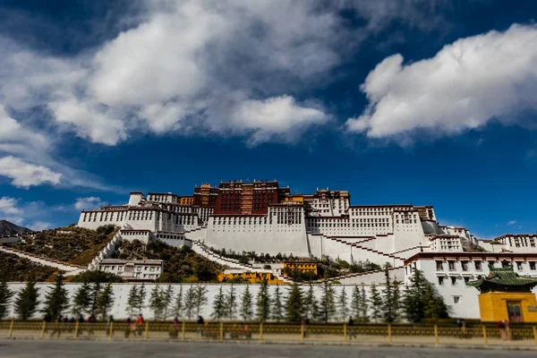 西藏首府 中国西藏拉萨的波塔拉宫 一个广角摄影在承关市 在路的一侧 可以看到钟彩 蓝天白云 — 图库照片