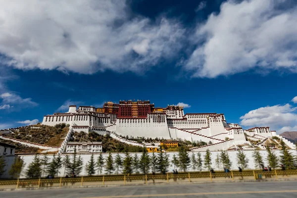 西藏首府 中国西藏拉萨的波塔拉宫 一个广角摄影在承关市 在路的一侧 可以看到钟彩 蓝天白云 — 图库照片