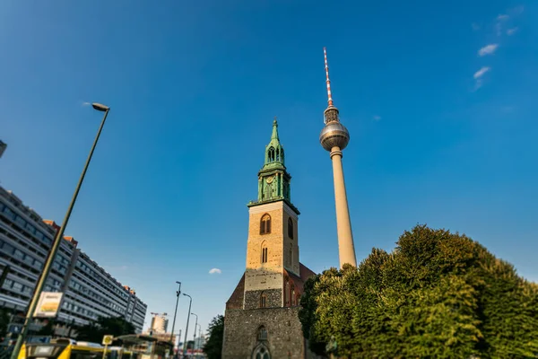 TV tower and St.Marien Church at the city of Berlin, Capital City of Germany. Fernsehturm und St. Marienkirche at Berlin before  Sunset. The top of the tower become golden from the falling sun
