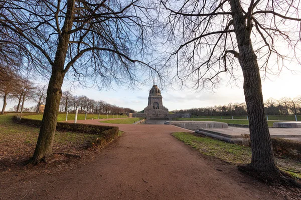 Almanya 'nın Saksonya eyaletinin Leipzig kentindeki uluslar arası savaş anıtının etrafındaki park. Soğuk kış havasında geniş bir açı yakalamak. Ağaçların yaprağı yok, mavi gökyüzü küçük bulutlarla kaplı.