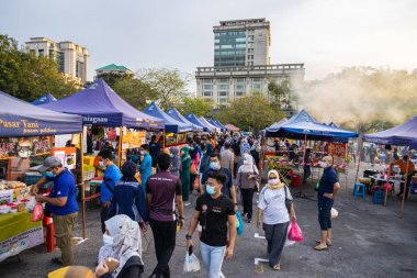 Başkent Kuala Lumpur yakınlarındaki Putrajaya 'daki taze pazar işlek. Covid-19 kısıtlamaları sırasında yüz maskeleri zorunludur. İnsanlar satın aldıklarını taşır.