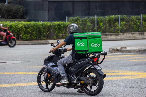 Kuala Lumpur, Malezya - 04 Ekim 2020: Motosikletle yiyecek teslimatçısı al. Corona krizindeki mevcut kısıtlamalar sırasında günlük yaşamı motosikletle yemek teslimatı belirliyor