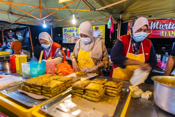 Kuala Lumpur yakınlarındaki Putrajaya 'daki sokak yemekleri pazarında. Türbanlı ve yüz maskeli Malezyalı Müslüman kadınlar geleneksel Murtabak yemeğini hazırlıyorlar. Bir koyun eti tabağı.