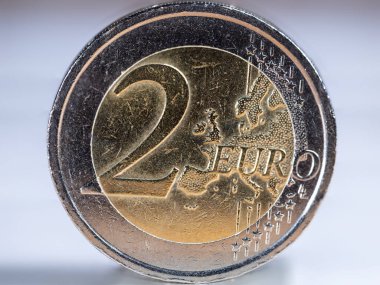 İki avroluk bir madeni paranın makro fotoğrafı. Yüksek çözünürlüklü, 2 avroluk bir ekb madeni parasının net bir şekilde ele geçirilmesi. Ön taraftaki bozuk para, bir Yunan sikkesi. Ortadaki büyük Avro karakteri