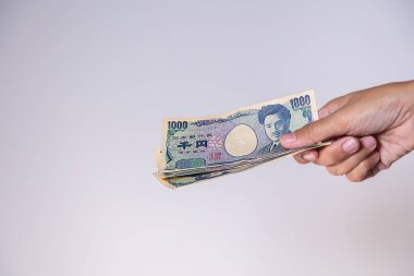 Kadın eli Japon yenini gösterir. Yen, Japonya 'nın para birimidir. Banknotların Obverse tarafında Hideyo Noguchi, 20. yüzyılın bakteriyolog. Japonya 'dan gelen kağıt para. Düşük değerli banknot