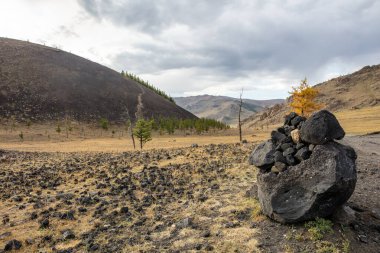 Orta Moğolistan manzarasının panoramik görüntüsü. Ulaan Batar 'a giden mühürsüz yol tozlu bir ip ya da bant gibi arazide dolanıyor. Ufukta kum tozu görünüyor..