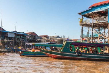 Gün batımında Kamboçya, Siem Reap yakınlarında Tonle Sap Gölü 'nde Kampong Phluk Yüzen Köyü. Yüzen kasabanın Stilt evleri. Güneydoğu Asya 'da egzotik yerler. Tekneler geziyor ve mal satıyor.