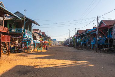 Tonle Sap Gölü yakınlarındaki Kampong Phluk Yüzen Köyü. Angkor Wat, Siem Reap, Kamboçya, gelgit ve gün batımı sırasında. Yüzen kasabanın Stilt evleri. Güneydoğu Asya. Tekneler geziyor ve mal satıyor.