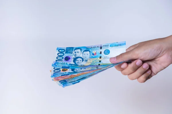 Filipinler Peso hayranı bir kadın elinde banknot. Kadın eli, Filipinli pezosu gösteriyor. Filipinler 'in parasını tutan kızların elleri. Asya parası. Bir Filipin peso hayranına yakın çekim
