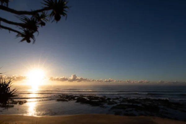 太阳升起在澳大利亚昆士兰州Yeppoon村的海滩上 在太平洋海岸阳光海岸附近 太阳在云层之间升起 反射在海水中 — 图库照片