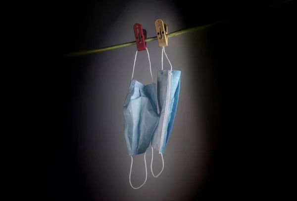 The last two face mask hanging on a rope. Face mask or Mouth mask are the most needed equipment during corona cov-19 crisis. No stock or sold out even though wearing a mask is mandatory in public. Black background