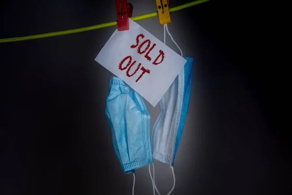 The last two face mask hanging on a rope. Face mask or Mouth mask are the most needed equipment during corona cov-19 crisis. No stock or sold out even though wearing a mask is mandatory in public. Black background