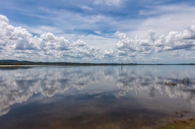 Minneriya Ulusal Parkı, Sri Lanka 'daki Minneriya Wewa Gölü üzerindeki ayna etkisi. Bulutlu manzara manzara fotoğrafçılığı. Su yüzeyindeki bulutların yansıması. Kümülüs bulutları