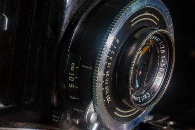 Leipzig, Sachsen, Almanya - 29 Eylül 2020: 50 mm 'lik katlanabilir mercekle 1960' ların başından kalma eski tozlu ve çizik bir fotoğraf makinesinin yakın çekimi. Çok eski bir kameranın merceğinin ayrıntıları