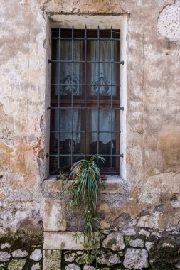 Eski bir çehrenin eski bir penceresi. Paslı pencereli ortaçağ, taş ve çelik cephe. Kimse yok.