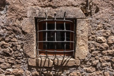 Eski bir çehrenin eski bir penceresi. Paslı pencereli ortaçağ, taş ve çelik cephe. Kimse yok.