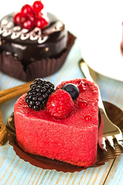 Pink cake with berries on wooden background — Stock Photo, Image