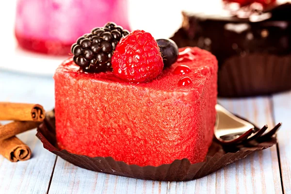 Pink cake with berries on wooden background — Stock Photo, Image