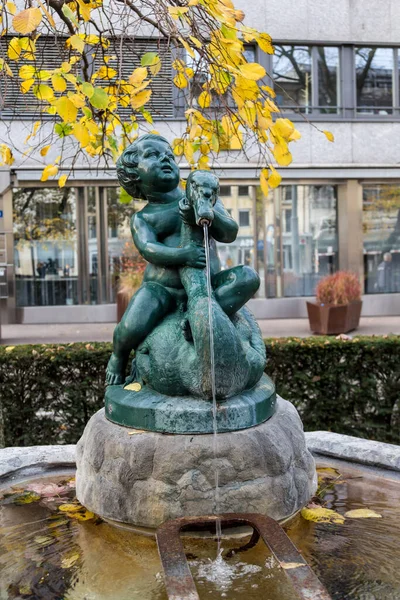 在巴塞尔市的一个公共喷泉上抱着天鹅的男孩 巴塞尔以许多不同雕塑形式的传统水源而闻名 — 图库照片