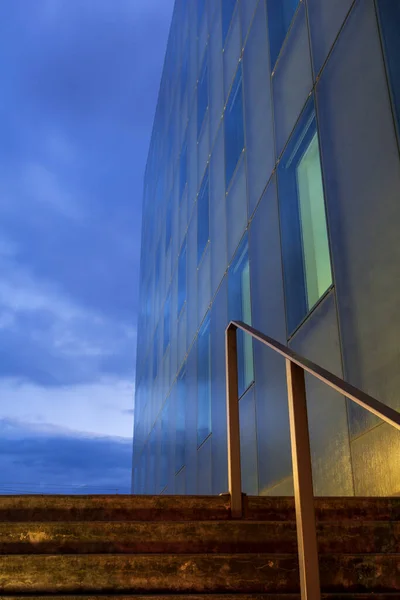 薄明時間の冷たい青の光と街灯からの暖かい光の現代建築 線とパターンと光源の混合物 — ストック写真