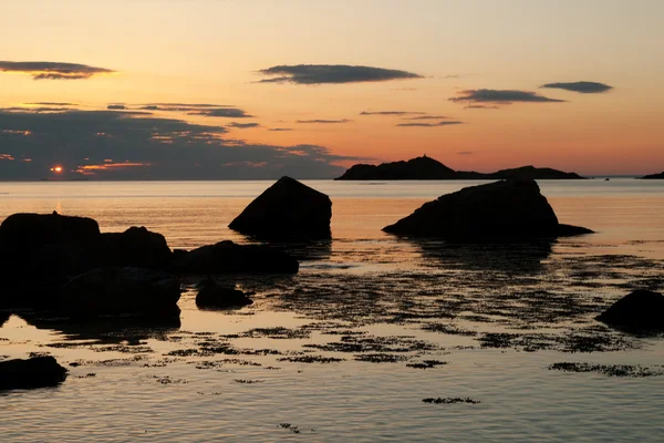 Sunset over sea with rocks in foreground — Stock Photo, Image