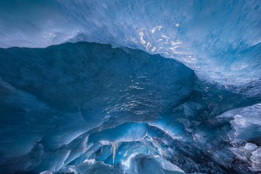 Buzul mağarasının içinde. Buzulun ağırlığı ve basıncının üstünde asılı buz kalıpları var.