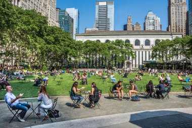 NEW YORK-JUNE 9: Manhattan şehir merkezindeki Bryant Parkı 9 Haziran 2015 'te New York' ta insanların konuşmaları ve rahatlamalarıyla dolu.