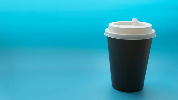 Environmentally friendly paper glass, beverage cup on a blue background. Copy space. Zero waste, no plastic concept.