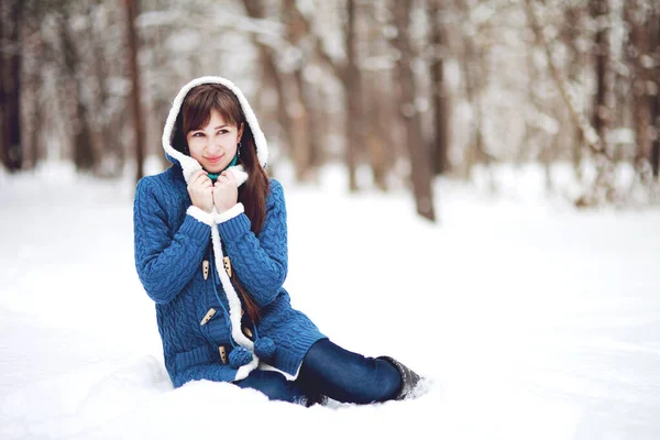 Zimowy portret pięknej dziewczyny w niebieskim swetrze na tle śnieżnego lasu — Zdjęcie stockowe