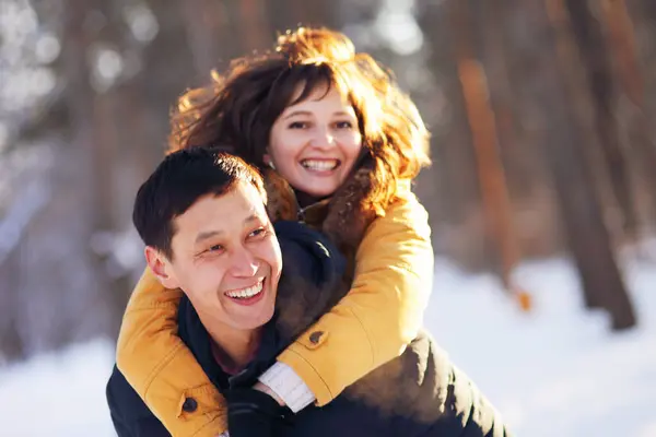 Jovem casal apaixonado se divertindo na floresta de inverno — Fotografia de Stock