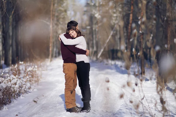 Casal jovem abraçar uns aos outros no inverno no parque — Fotografia de Stock