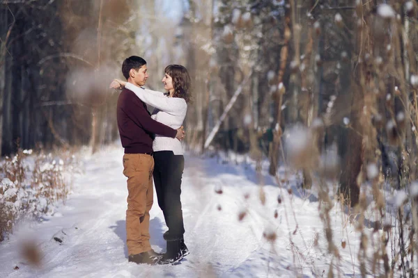 Casal jovem abraçar uns aos outros no inverno no parque — Fotografia de Stock