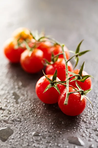 Siyah taş yüzeyi kiraz domates — Stok fotoğraf