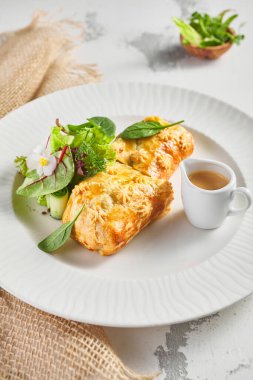 Karaciğer ve krema soslu turta. Taze yeşil yapraklarla süslenmiş. Çuval bezli beyaz tabak.