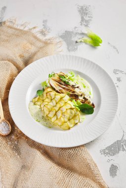 Salatalık pullu balık ve lahana bifteği. Taze yeşilliklerle süslenmiş. Aydınlık masaya çuval bezi ve beyaz kaplama