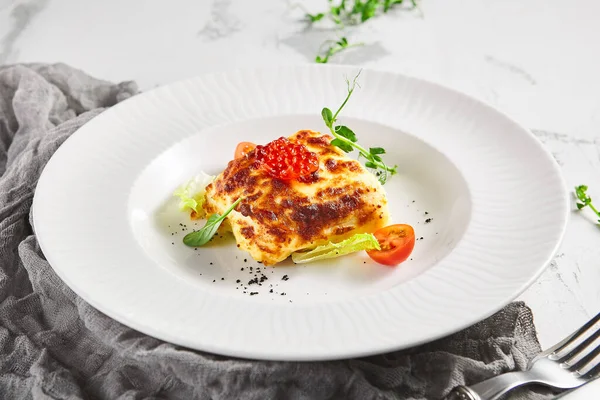 トマトと緑の葉とラザニア ベシャメルソースの魚 テーブルの上の白いレストランプレート — ストック写真