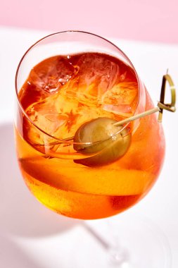 Pembe arka planda Aperol spreyi. Pembe ve beyaz arka plan. Sert ışık ve gölge