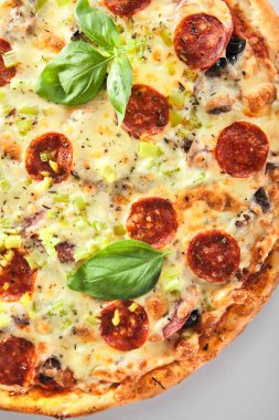 İtalyan pizzacılarının metal tepsisinde mermer sığır eti, jambon, salam ve sucuklu pizza. Geleneksel İtalyan pizzası, pişmiş dana eti, mozzarella ve fesleğen ile buluşur.