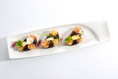 Kızarmış ekmeğin üstüne ördek ezmesi ve trüf yağı. Beyaz restoran tabağında kuru erik kreması. Ev yapımı ciğer püresi, erik, patates cipsi ve sebzeli Fransız tostu.