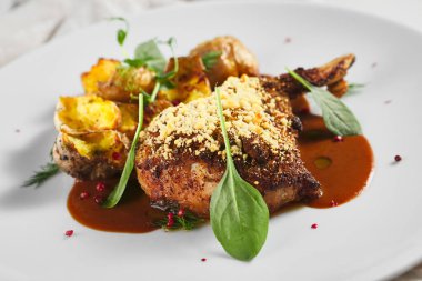 Kızarmış domuz filetosu ve patatesli Demi-Glace. Kaba ahşap masa, kumaş ve taze yeşil ıspanak.