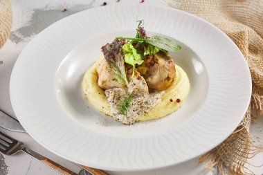 Patates püresi ve tavuk dürümü. Kırsal beyaz masada beyaz tabak ve çuval bezi.