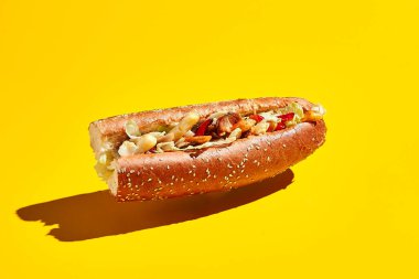 Sarı arka planda sandviç havalanması. Asgari yaratıcı gıda konsepti. Susamlı vejetaryen sandviç.