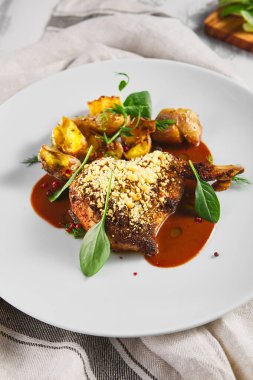 Kızarmış domuz filetosu ve patatesli Demi-Glace. Kaba ahşap masa, kumaş ve taze yeşil ıspanak.