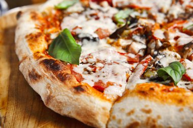 Mantarlı pizza ve tahta tepside domates.