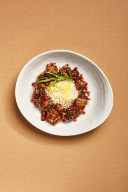 Başında basmati olan çeşitli etler. Kalın tabakta pirinçli portakal suyu. Lüks restoran lezzeti servisi. Gurme yemek bölümü. Aşçılık sanatı. Yandan yemek al. Süslü yemek kursu